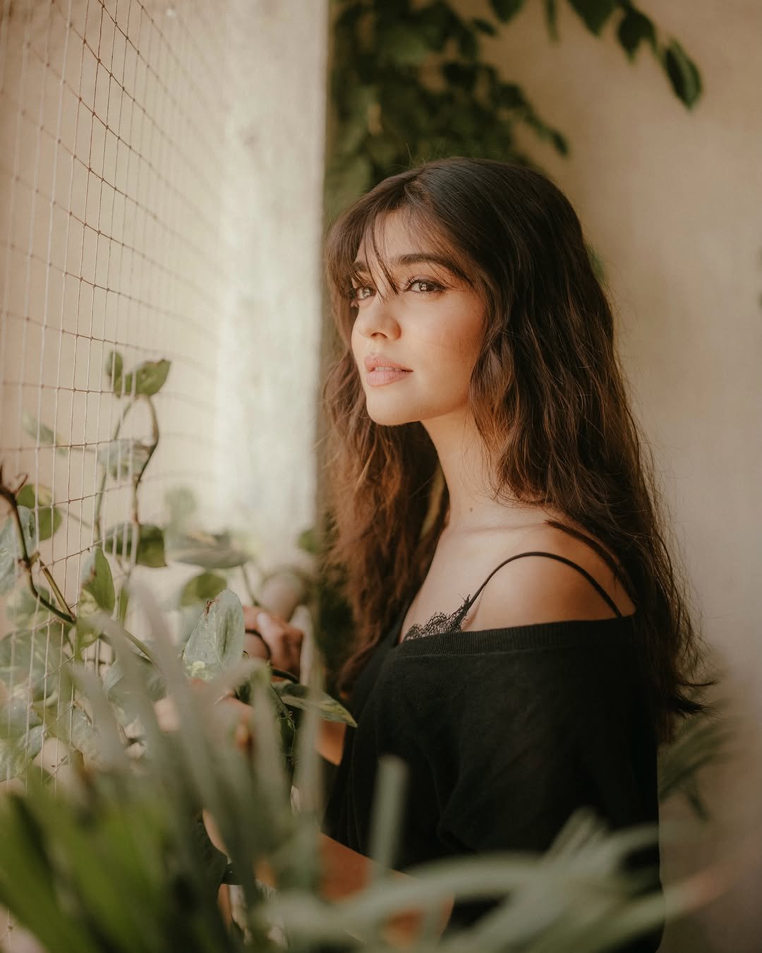 Pranali Rathod poses beside leafy plants
