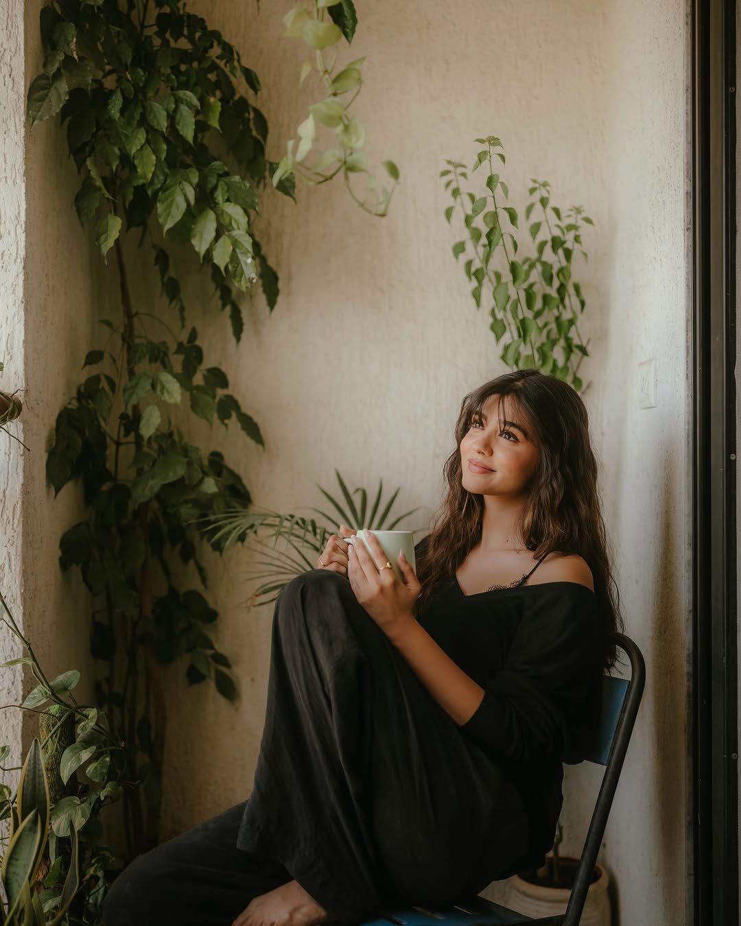 Pranali Rathod sits holding a mug