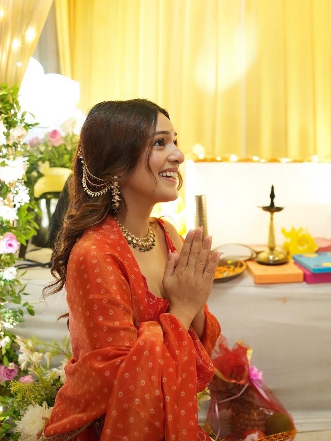 Rj Mahvash Mahvash smiles in red traditional clothing indoors